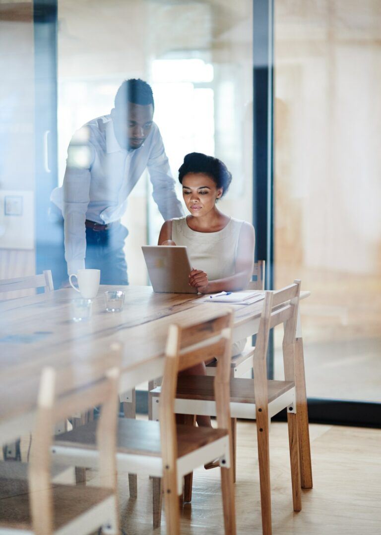 Sharing ideas and success. Shot of colleagues using a digital tablet together in an office.